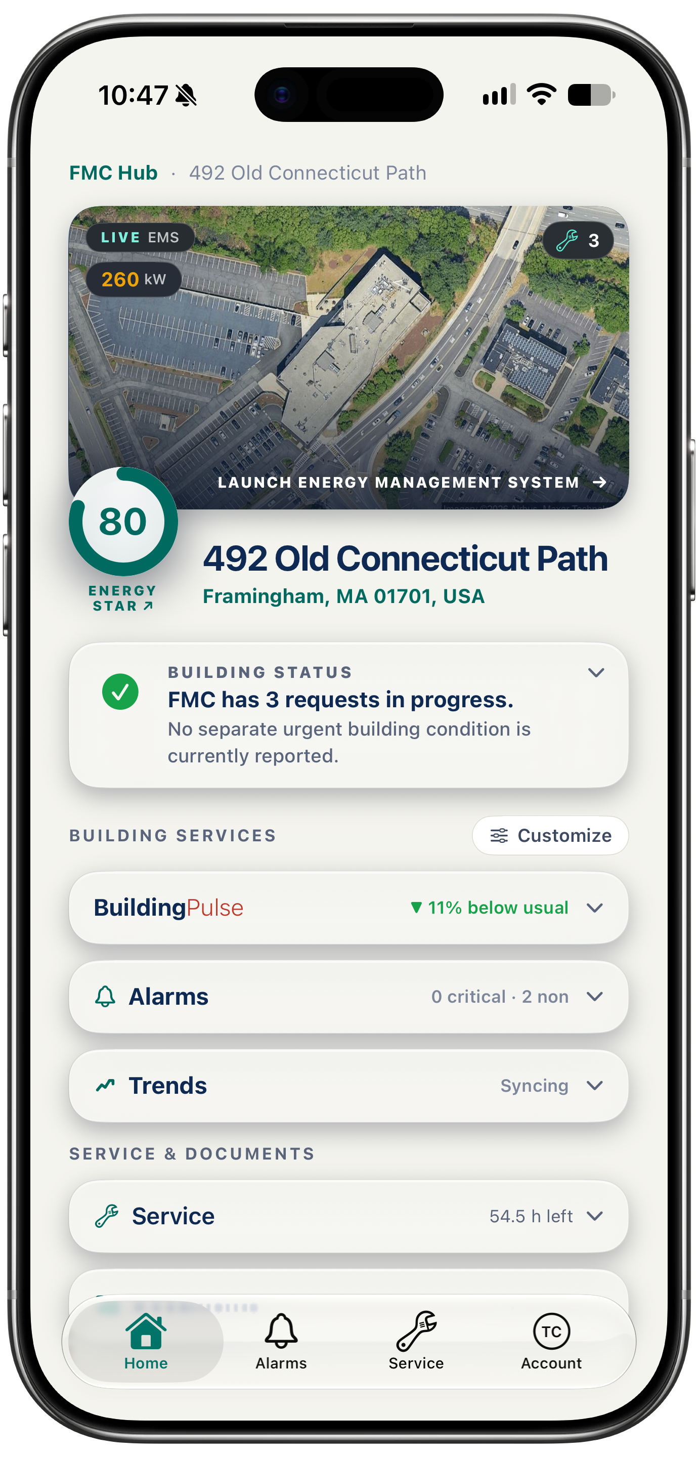 A single location page in the FMC Customer Hub on an iPhone: the building from above, its status, and links to its energy management system, BuildingPulse, alarms, trends, service and documents